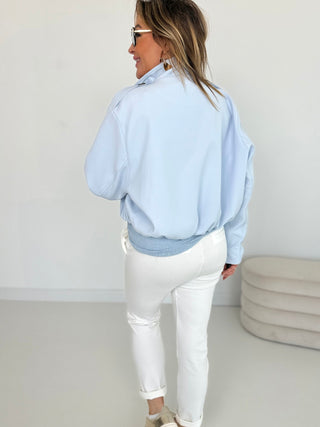 Hellblaue Jacke, schlicht von hinten zu sehen